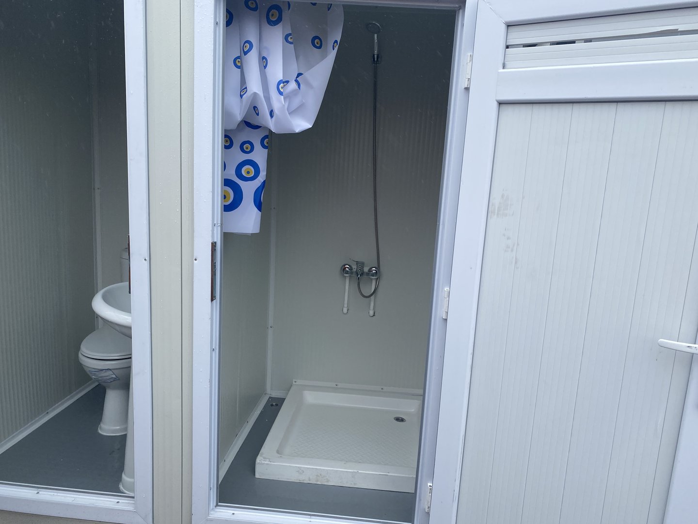 Contenedor sanitario con inodoro y ducha.