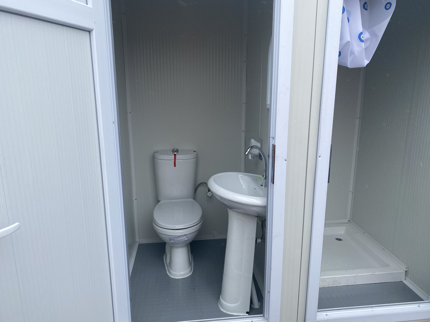 Contenedor sanitario con inodoro y ducha.